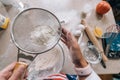 Woman& x27;s hands sifting flour through sieve. Selective focus. Royalty Free Stock Photo