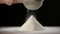 Woman's hands sifts flour through a sieve on the flour heap, slo