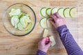 WomanÃ¢â¬â¢s hands taking granny smith apple slices out of a glass bowl and laying them out on a mesh tray for dehydrating Royalty Free Stock Photo