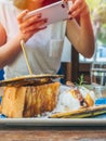 Woman`s hands taking photo of the dessert on wooden table by smartphone Royalty Free Stock Photo