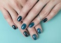 Woman`s hands with turquoise manicure on creative background