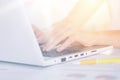 Woman`s hands typing on keyboard of notebook, sitting at table against white background, white lap top and yellow pen on desk, Royalty Free Stock Photo