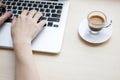 Woman`s hands typing on laptop keyboard with a cup of coffee Royalty Free Stock Photo