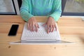 woman's hands typing on a laptop with smart phone on wood table Royalty Free Stock Photo