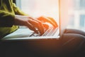 Woman`s hands typing on laptop, young female blogger or student sitting next to window and working Royalty Free Stock Photo