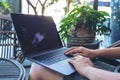 Woman`s hands using and typing on laptop touchpad while sitting in the outdoors Royalty Free Stock Photo