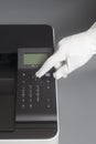 Woman`s hands in white glove pressing button on control panel color laser printer Royalty Free Stock Photo