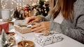 Woman s hands wrapping Christmas gift boxes, close up. Unprepared presents on white table with decor elements and items Royalty Free Stock Photo