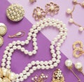 Woman`s Jewelry. Vintage jewelry background. Beautiful gold tone and pearls brooches, braceletes, necklaces and earrings on purpl Royalty Free Stock Photo