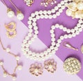 Woman`s Jewelry. Vintage jewelry background. Beautiful gold tone and pearls brooches, braceletes, necklaces and earrings on purpl Royalty Free Stock Photo