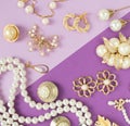 Woman`s Jewelry. Vintage jewelry background. Beautiful gold tone and pearls brooches, braceletes, necklaces and earrings on purpl Royalty Free Stock Photo