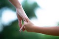 Woman`s and kid`s hands. Mother lead his child, summer nature outdoor. Parenting, togetherness, help, union, childhood, trust,