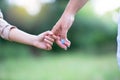 Woman`s and kid`s hands. Mother leads her child, summer nature outdoor. Parenting, togetherness, help, union, childhood, trust,