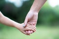 Woman`s and kid`s hands. Mother leads her child, summer nature outdoor. Parenting, togetherness, help, union, childhood, trust,