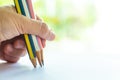 Woman left Hand holding 5 multicoloured pencils Yellow, Pink, White, Blue colour, writing letter on white paper, Bokeh green Royalty Free Stock Photo