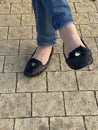 Woman`s legs in blue jeans and black pumps shoes