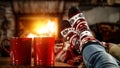 Woman`s legs with christmas socks and red mugs of coffee or tea and home interior with fireplace and dark wall background. Royalty Free Stock Photo