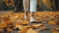 A Woman\'s Legs Gracefully Adorned in Trendy Footwear, Strolling Through an Autumn Park