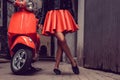 Woman`s legs near red scooter. Royalty Free Stock Photo