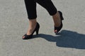 Woman`s legs with red nails polished in black sandals