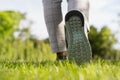 Woman`s legs wear sports shoes, Jogging on the green grass in the park at morning, Healthy lifestyle concept Royalty Free Stock Photo