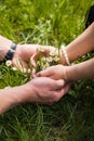 Woman's and man's hands and bouquet of camomiles on grass Royalty Free Stock Photo