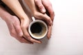 Woman's and man's hands holing cup of coffee