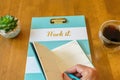 Woman`s manicured hand writing in date book on clipboard with words `Work It` Royalty Free Stock Photo