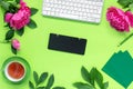 Woman\'s modern workspace. Keyboard, glasses and office supplies on green table.