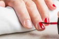 Woman`s nails manicured with red nail polish