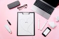 Woman`s pink office desk with headphones laid out like a heart. Woman`s workplace with laptop, smart phone with blank Royalty Free Stock Photo