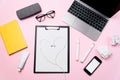 Woman`s pink office desk with headphones laid out like a heart. Woman`s workplace with laptop, smart phone with blank Royalty Free Stock Photo