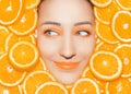 Woman`s portrait with oranges closeup. Bright orange make up