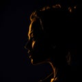 Woman\'s profile in shadow with reflections of golden light