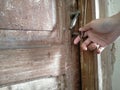The woman`s right hand held the old key, in the lock of the old wooden door Royalty Free Stock Photo