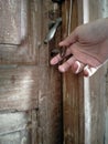 The woman`s right hand held the old key, in the lock of the old wooden door Royalty Free Stock Photo
