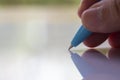 Woman right Hand holding blue plastic ballpoint pen, Writing letter on white acrylic background, Business, Education Royalty Free Stock Photo