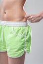 Woman assesses fat over shorts, fitness uncertainty Royalty Free Stock Photo