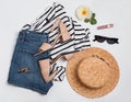 Woman`s summer outfit with striped shirt, jeans shorts, beige sandals and other