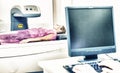 Woman in 40s undergoing medical x-ray with elderly doctor looking at monitor