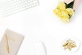 A woman`s workspace, working at home or in the office. Copy space for a blogger: keyboard, a bunch of yellow tulips, paper clips