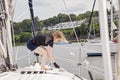 Woman on sailboat ties rope to cleat