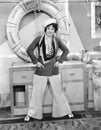 Woman in a sailors outfit in front of a life preserver Royalty Free Stock Photo