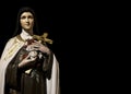 Woman Saint Sculpture Holding Cross Over Black Background