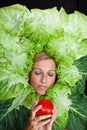 Woman with salal leafes around her head.