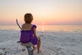 Woman on sand beach romantic sky at sunset, rear view silhouette, golden sunlight, real people. Indonesia, Kei islands, Moluccas