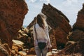 Woman among sandstones on seashore