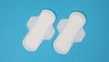 Woman sanitary napkins on blue background. Top view