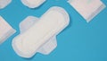 Woman sanitary napkins on blue background. Top view