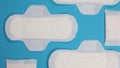 Woman sanitary napkins on blue background. Top view